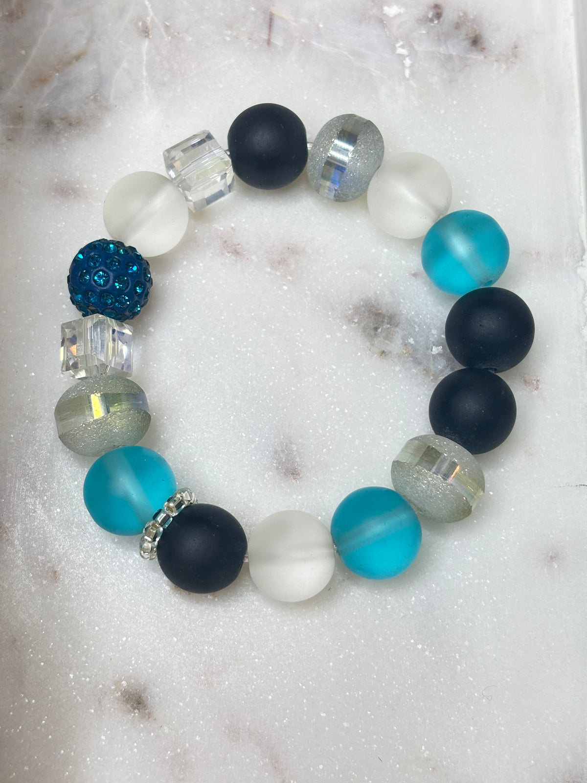Velvet Tide bracelet with black, frosted white, aqua, and silver-toned beads and teal crystal accents.