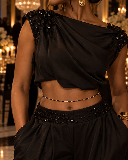 Model wearing Gilded Noir black, clear, and gold waist beads with a black outfit