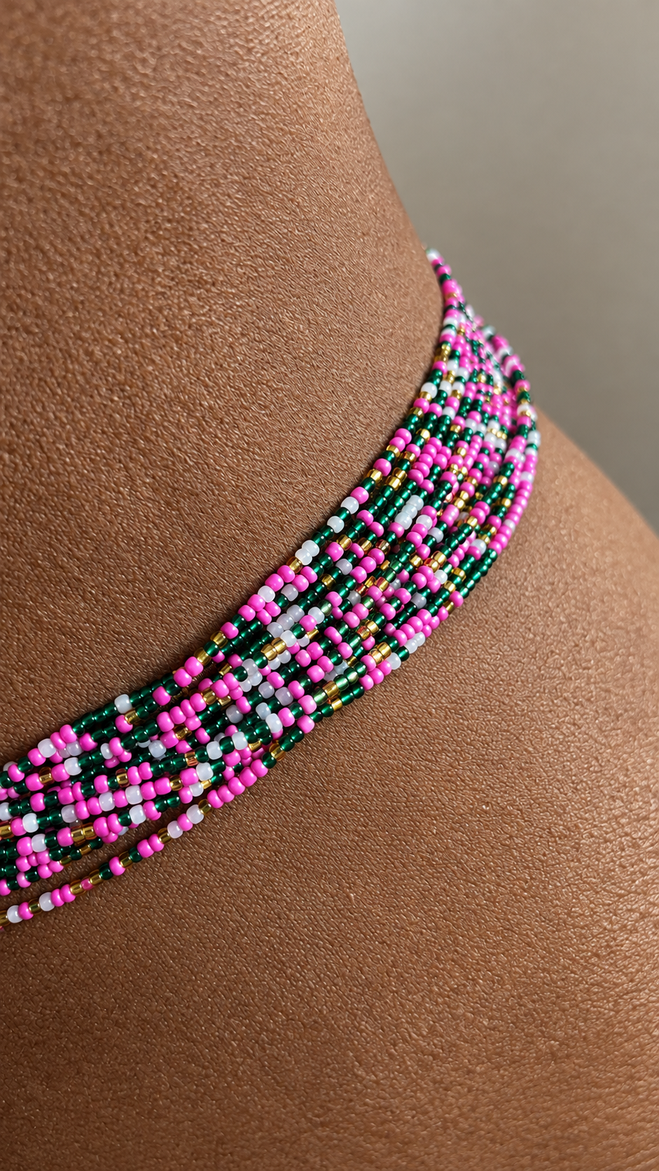 Model in a white suit wearing Blossom Royale multicolor waist beads