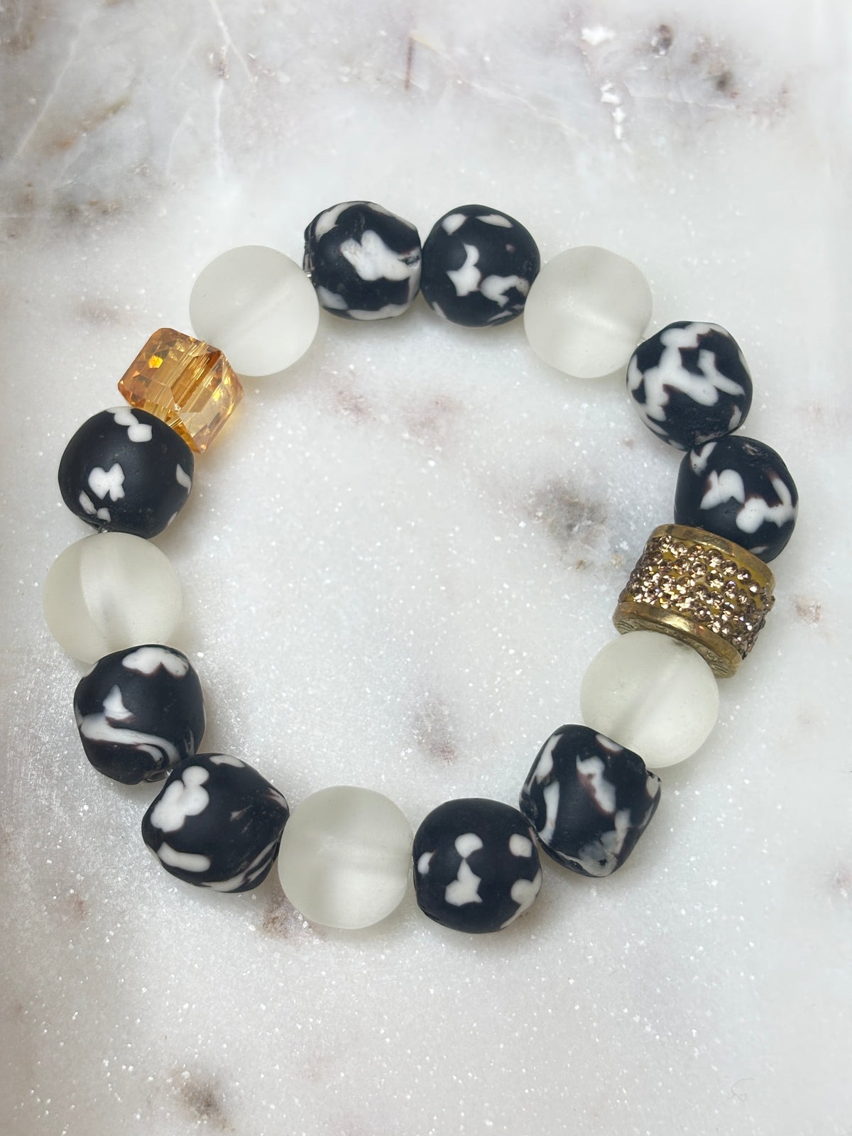 Ivory Smoke bracelet with frosted white glass, black-and-white Krobo beads, amber crystal, and gold-tone accents.