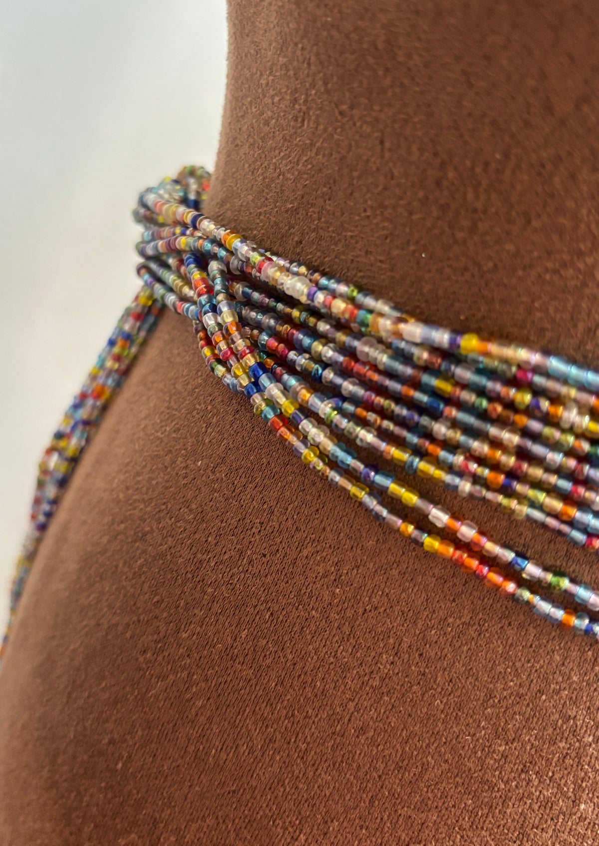 Close-up of Mélange multicolor jewel-tone waist beads worn at the waist