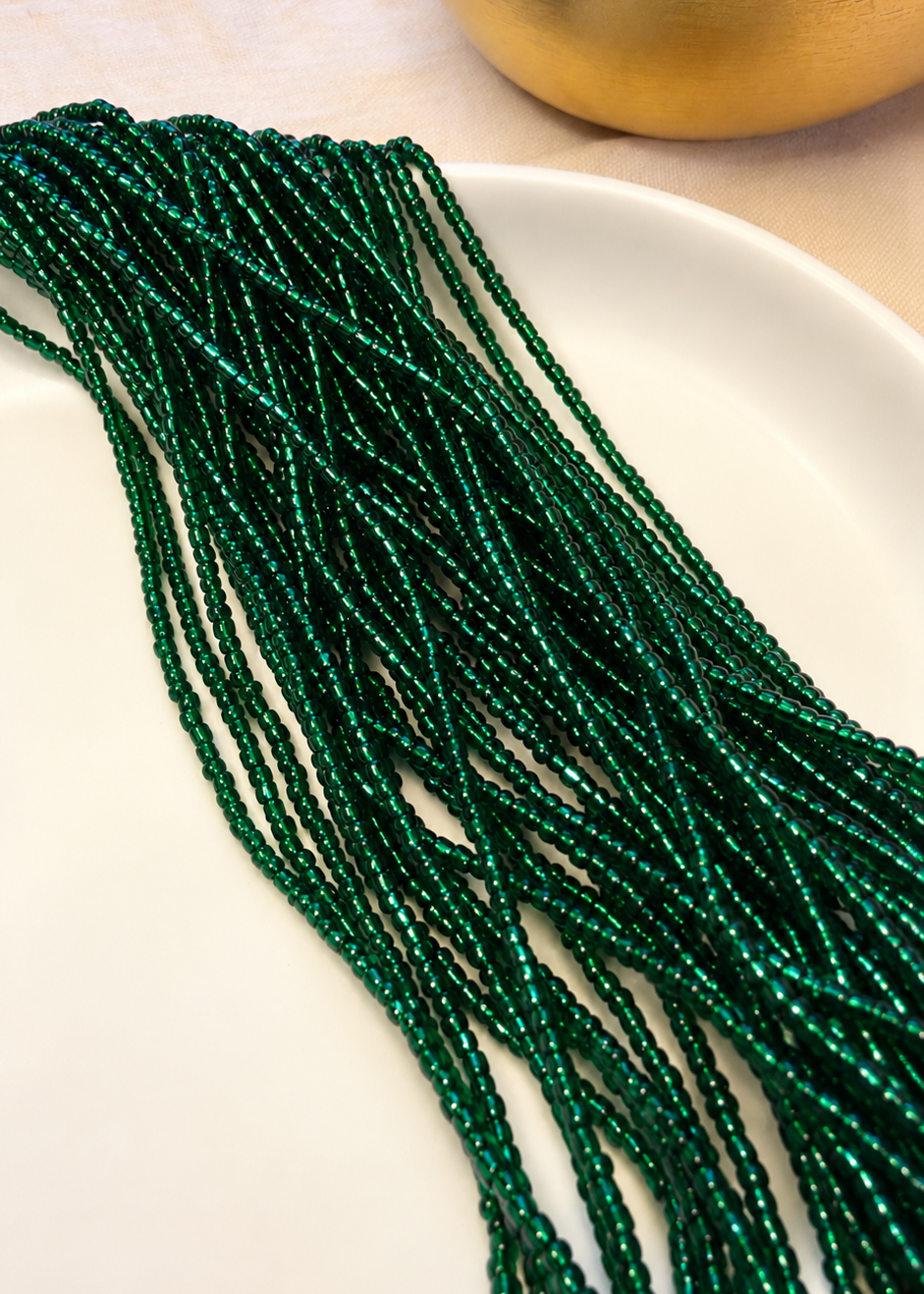 Eden deep emerald green waist beads draped across a white dish