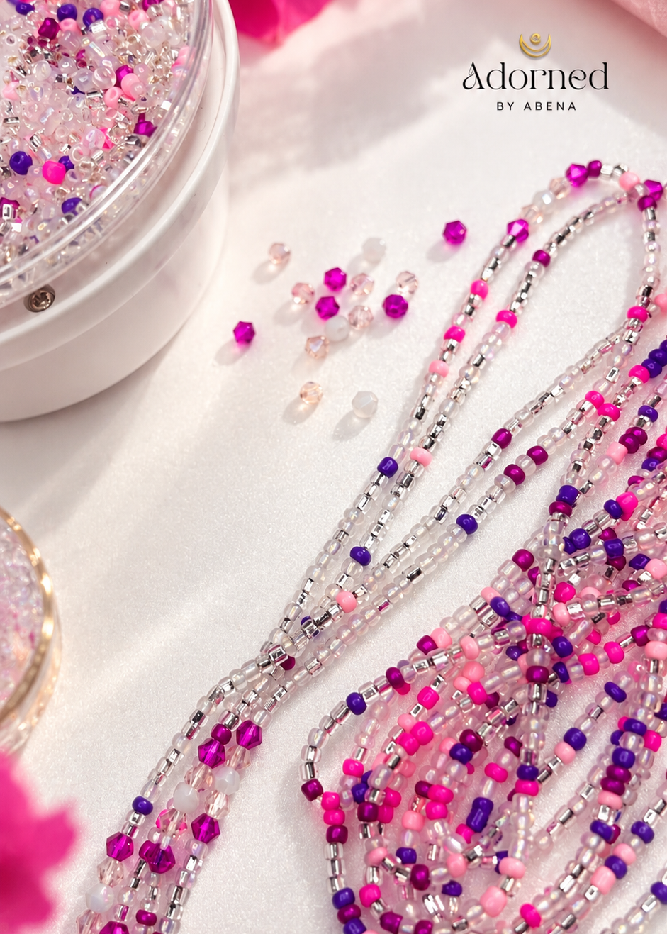 Pink Reign Luxe waist beads displayed beside a bowl of beads with Adorned by Abena branding