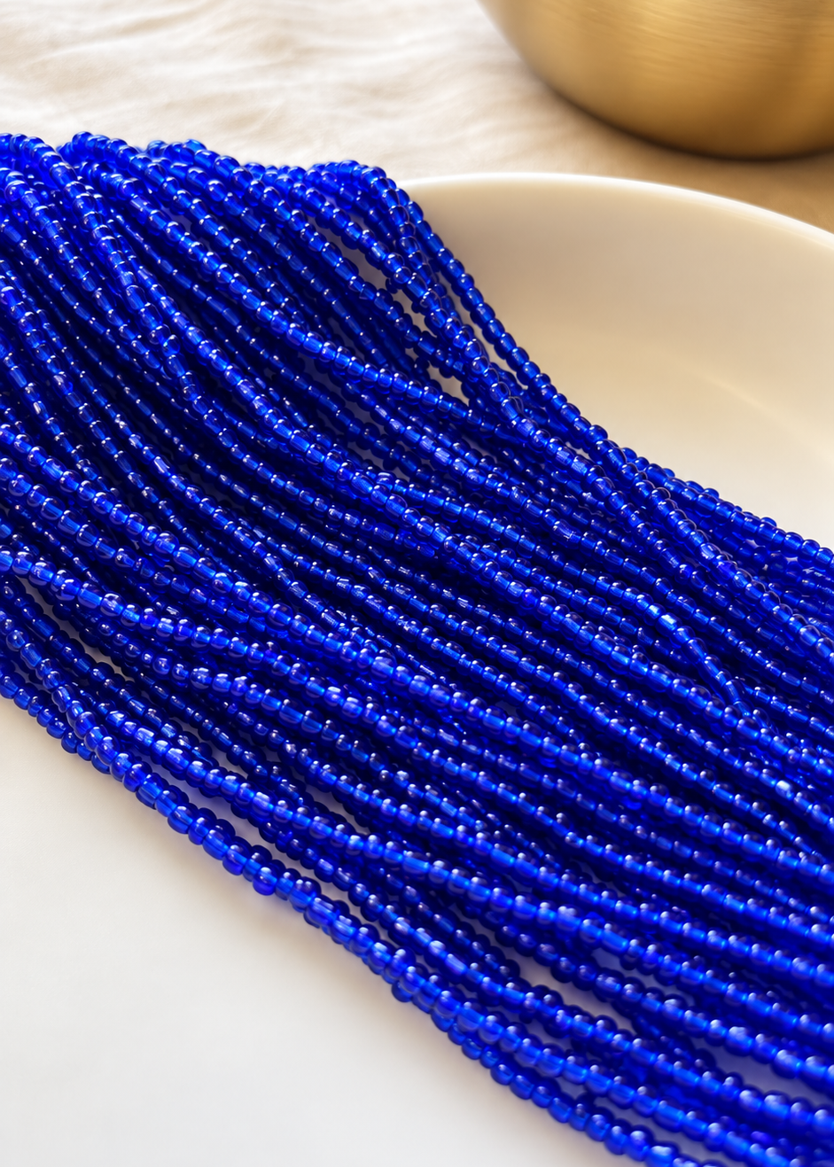 Riviera waist beads in vibrant blue arranged on a dish