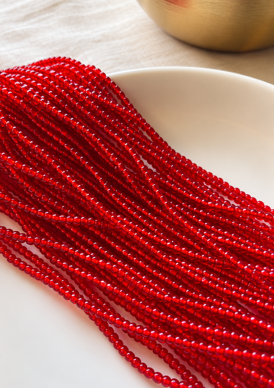 Mi Amor red waist beads arranged on a white dish