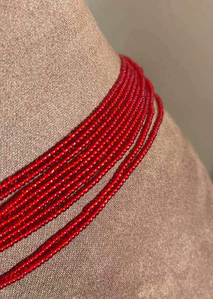Close-up of red Mi Amor waist beads on a display form