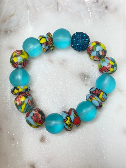 Ocean Bloom bracelet with aqua glass, multicolor Krobo beads, and a teal crystal focal bead.