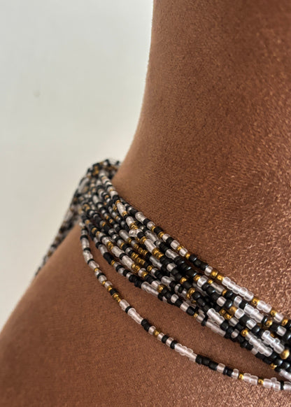 Close-up of Gilded Noir clear, black, and antique gold waist beads worn at the waist