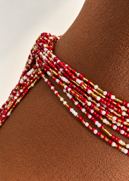 Close-up of Lover Girl red, gold, and pearl white waist beads worn around the waist