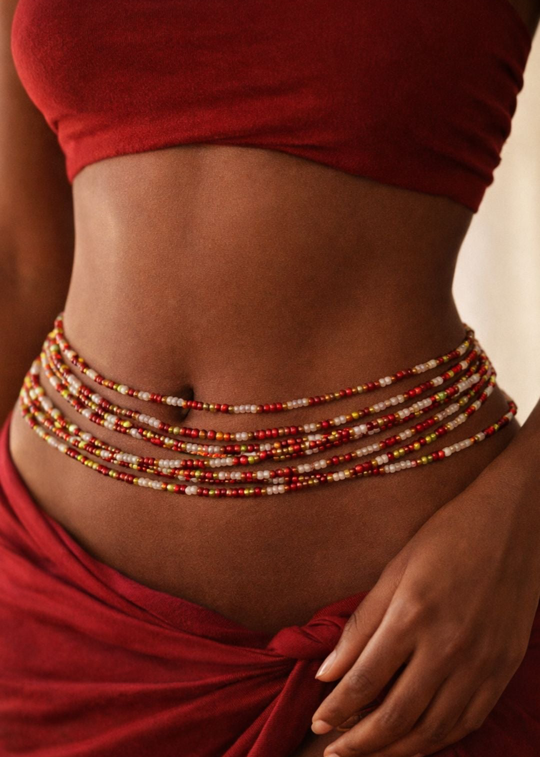 Model wearing Lover Girl red, gold, and pearl white waist beads with a red outfit