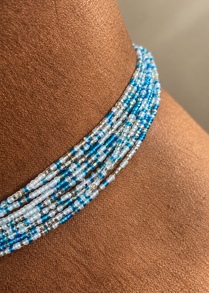 Close-up of Something Blue waist beads in blue, white, and silver worn at the waist