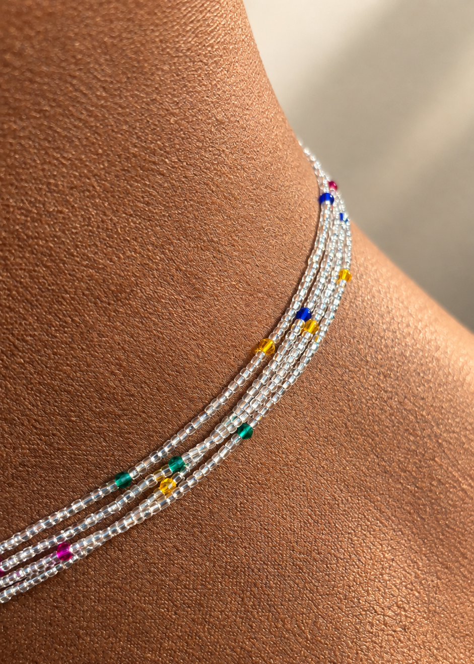 Close-up of Celestial Spark Luxe waist beads worn on skin, showing silver-lined clear beads and multicolor crystal accents