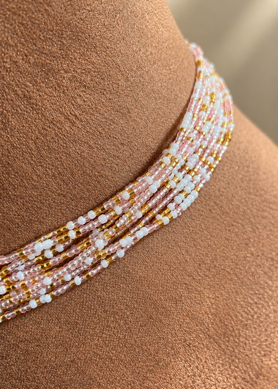 Close-up of Blushing Goddess waist beads on skin, showing blush pink, pearl white, and gold tones