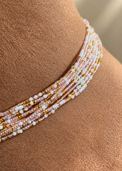 Close-up of Blushing Goddess waist beads on skin, showing blush pink, pearl white, and gold tones