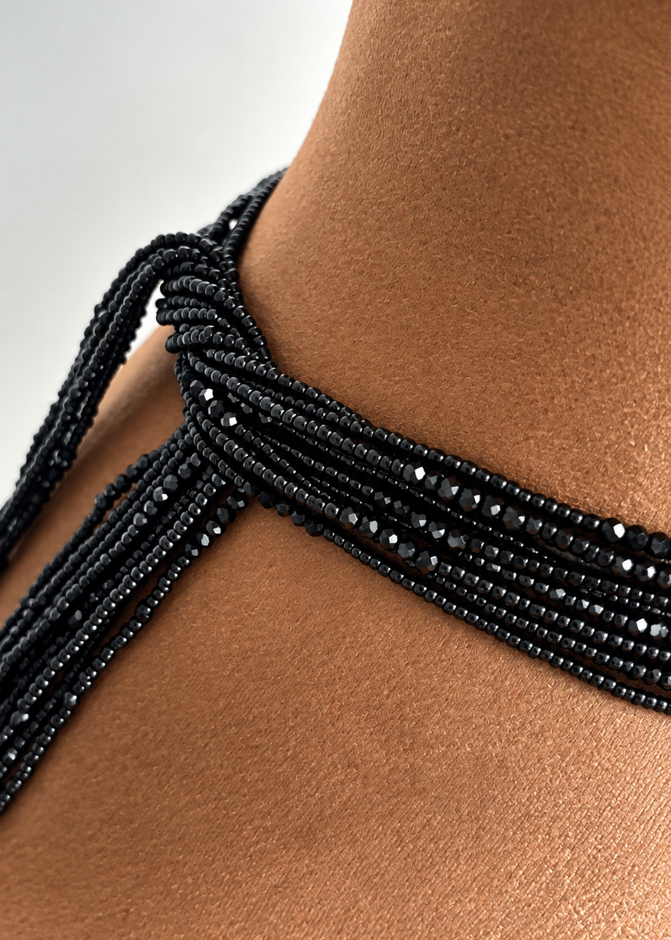 Close-up of black Obaa Tuntum Luxe waist beads with faceted crystal accents