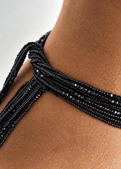 Close-up of black Obaa Tuntum Luxe waist beads with faceted crystal accents