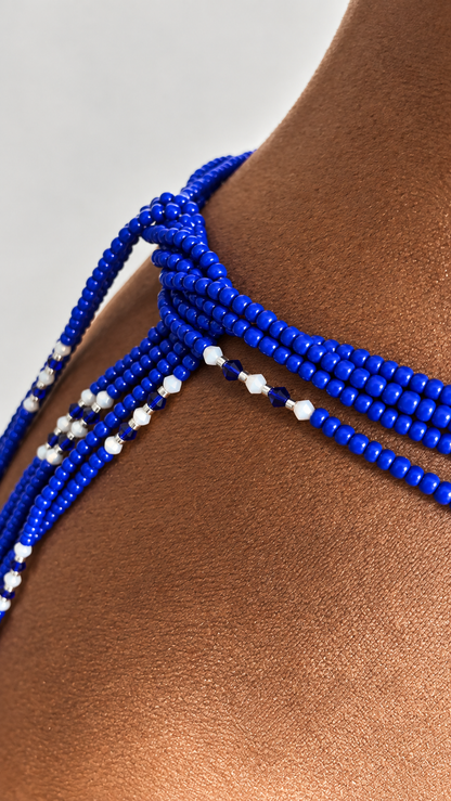 Close-up of cobalt blue SapphiHER waist beads with white accent beads on a display form
