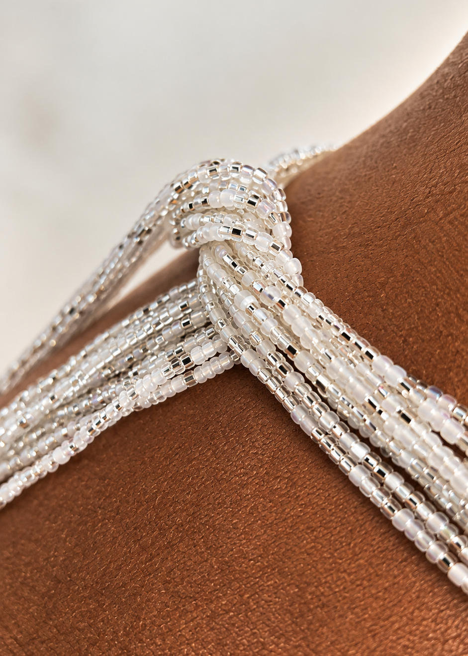 Close-up of silver and iridescent white Silver Bloom waist beads worn at the waist