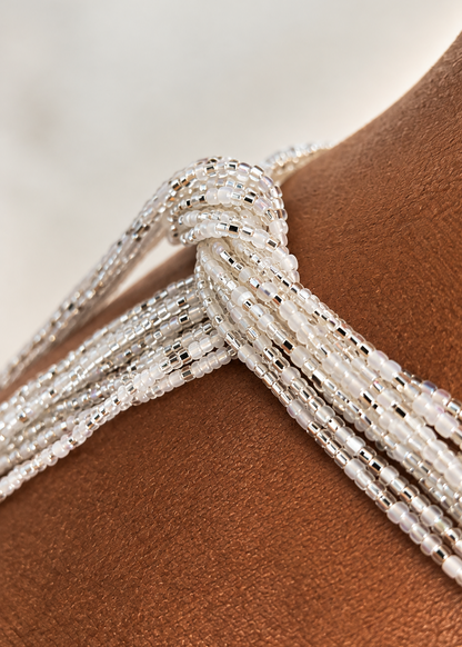 Close-up of silver and iridescent white Silver Bloom waist beads worn at the waist