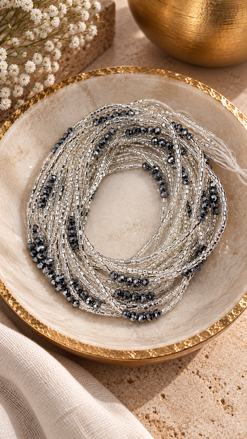 Silver Whisper Luxe waist beads with metallic gray accents arranged in a dish