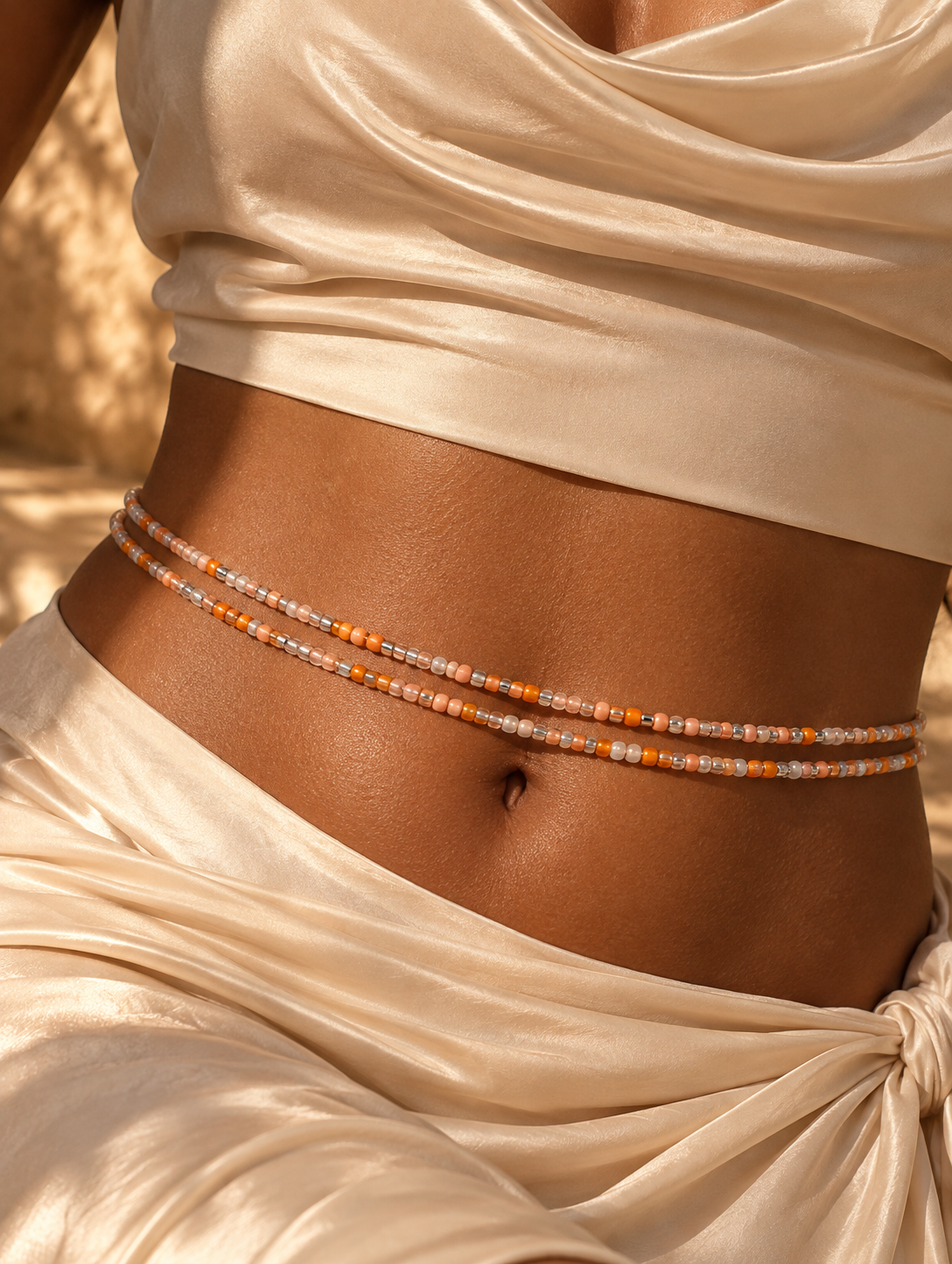 Close-up of Demure de Brittany peach, pearl, and silver waist beads worn at the waist