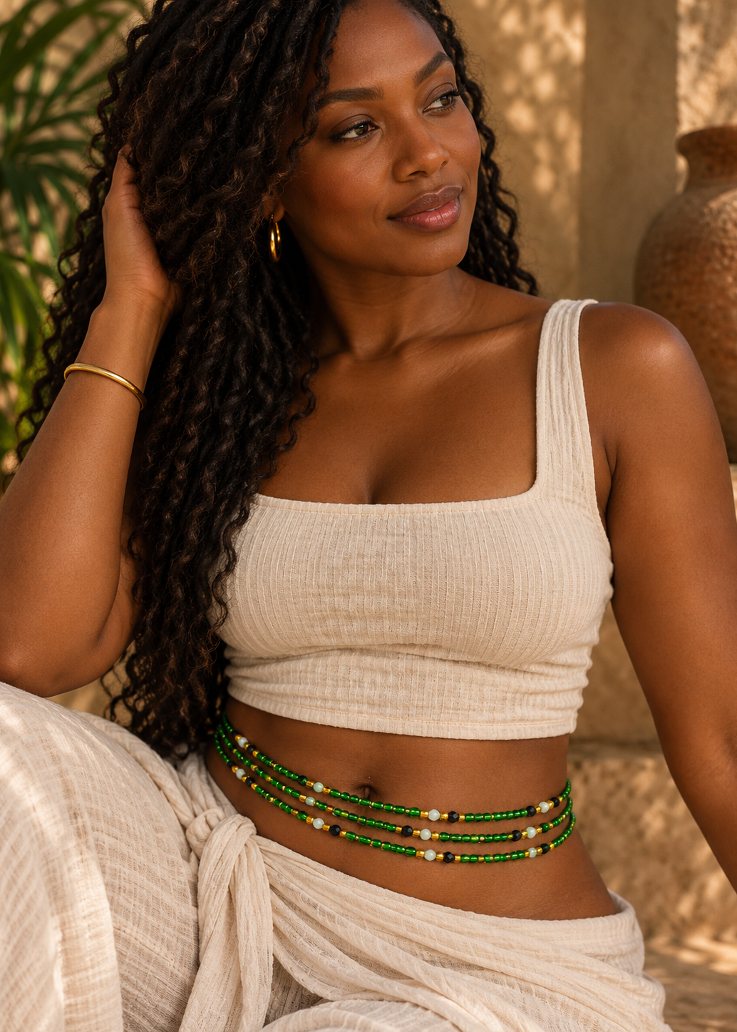Close-up of Emerald City green, black, gold, and white waist beads worn at the waist
