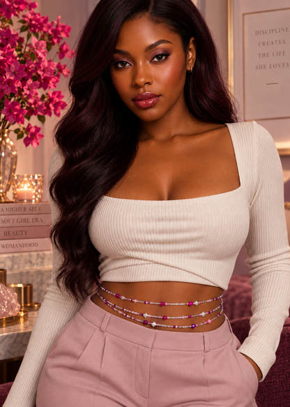 Model wearing layered Pink Reign Luxe waist beads with a white top and pink trousers